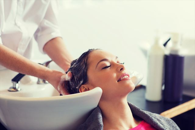 美容室のスカルプシャンプーで髪を洗う女性の画像